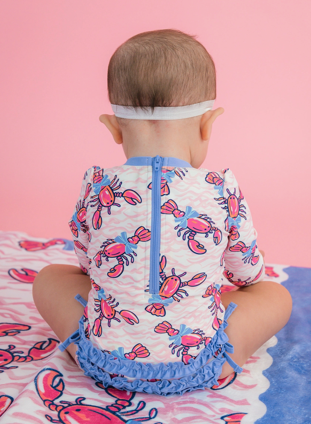 RuffleButts – Baby Girls Pink Lobster Lagoon Long Sleeve One-Piece Rash Guard Swimsuit
