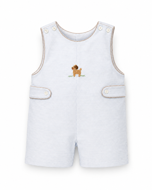 A baby's sleeveless romper in white and light blue micro-stripe fabric, featuring a small embroidered brown dachshund on the chest, beige contrast piping, and snap closures on the shoulder straps and front pockets.